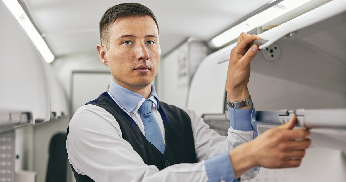 comissário de bordo dentro do avião abrindo o bagageiro processo seletivo comissário de bordo